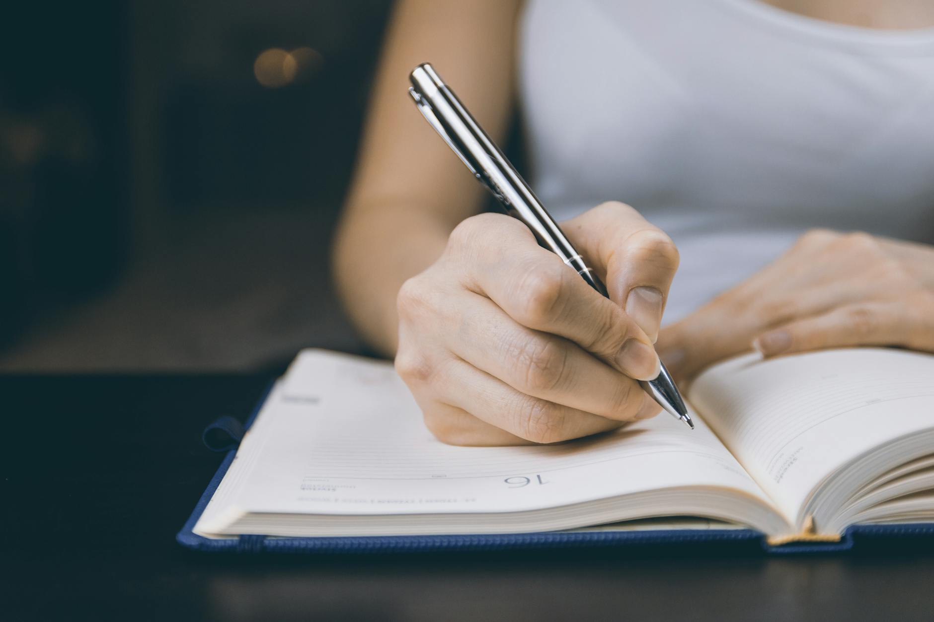 photo of person writing on notebook