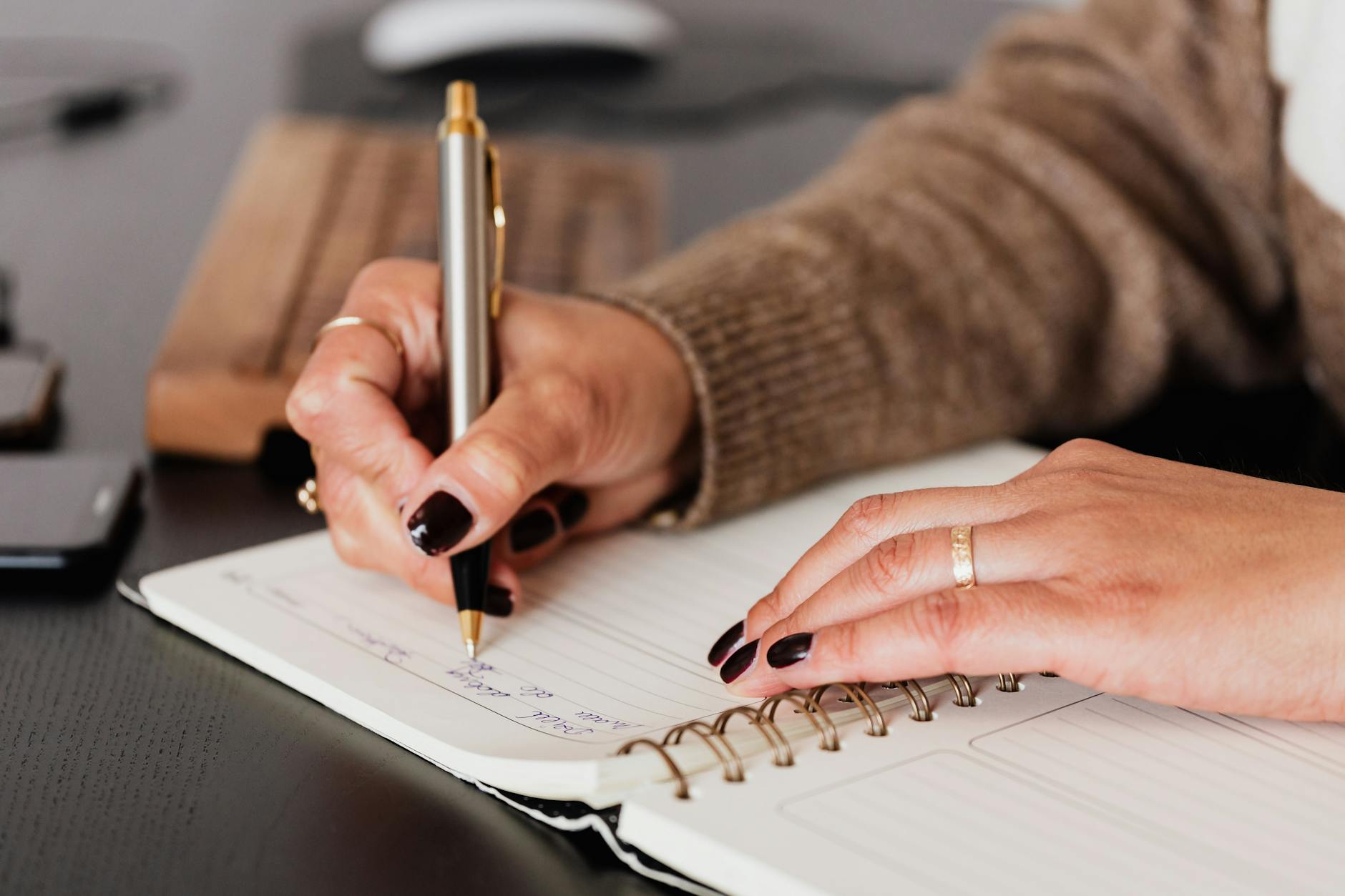 woman writing down notes in a journal